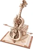 A 3D mechanical wooden cello model with intricate gears and a bow, resting on an open book. Voir les images du produit