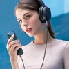 A woman wearing headphones is holding a smartphone and listening to music. Anteprima dell’immagine prodotto