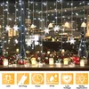 A window decorated with Christmas lights and snowflakes, with small Christmas trees and candles on the windowsill. Anteprima dell’immagine prodotto