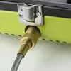 A close-up view of a gas hose connector attached to a green camping stove. Anteprima dell’immagine prodotto