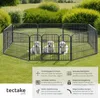 Three golden retriever puppies are inside a black metal playpen set up on a grassy lawn with bushes in the background. Voir les images du produit