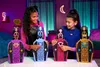 Two young girls are playing with Monster High dolls and their accessories in a colorful room. Voir les images du produit