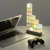 A Minecraft-themed building block lamp is displayed on a desk next to a laptop and a game controller. Náhľad obrázku produktu