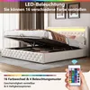 A white upholstered bed with its storage compartment open, showcasing LED lighting and a remote control. Produktbild-Vorschau