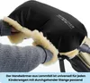 Hands wearing a black hand warmer with cream-colored lining, attached to a stroller handle. Produktbild-Vorschau