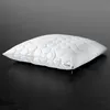 A white pillow with a quilted pattern is shown on a dark surface. Produktbild-Vorschau