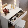 A white vanity table with drawers, makeup, and a stool, illuminated by LED lights. Voir les images du produit