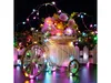 A decorative bicycle basket filled with flowers and illuminated by colorful string lights. Podgląd zdjęcia produktu