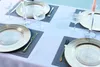 A table setting with plates, glasses, and cutlery on a tablecloth. Podgląd zdjęcia produktu