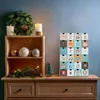 A wooden advent calendar with animal designs and numbered doors is displayed on a wooden dresser, next to a wooden shelf unit with Christmas decorations. Náhľad obrázku produktu