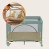 A woman is looking into a baby playpen where two babies are playing. Náhľad obrázku produktu