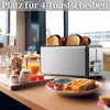 A toaster with bread in it, along with breakfast items like juice and jam, on a kitchen counter. Podgląd zdjęcia produktu