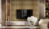 A modern living room with a TV mounted on a textured wall, a sleek media console, and a comfortable armchair. Produktbild-Vorschau