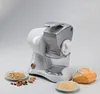 A white and silver Ariete Grati Professional cheese grater is displayed on a white background, with small bowls of nuts and breadcrumbs, and a loaf of bread. Podgląd zdjęcia produktu