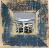 A rustic wooden picture frame with a dark blue distressed finish, showcasing a scene of an outdoor cafe with tables and chairs on a sandy beach. Produktbild-Vorschau