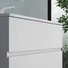 A close-up view of a white bathroom vanity cabinet with a white countertop and a white faucet. Produktbild-Vorschau
