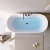 A top-down view of a modern bathroom with a freestanding bathtub filled with blue water, a rug, and slippers. Náhled obrázku produktu