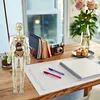 A human anatomy model is displayed on a wooden desk next to notebooks, a camera, and a vase of flowers. Anteprima dell’immagine prodotto