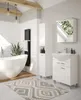 A modern bathroom with a freestanding bathtub, a tall white cabinet, a vanity with a sink and faucet, and a radiator. Náhľad obrázku produktu