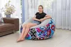 A young girl is sitting on an inflatable chair in a living room. Produktbild-Vorschau