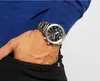A person's hand with a watch is placed in the pocket of black pants. Náhled obrázku produktu