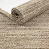 A close-up view of a rolled-up rug, showing its textured surface and rolled edge. Produktbild-Vorschau