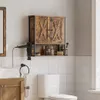 A bathroom scene featuring a wall-mounted cabinet above a toilet, with a hairdryer and towel rack nearby. Náhled obrázku produktu