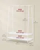 A white metal garment rack with two shelves is shown with dimensions and weight capacities indicated by text and arrows. Náhled obrázku produktu