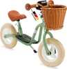 A green Puky balance bike with a wicker basket and brown seat and handlebars, shown against a white background. Produktbild-Vorschau