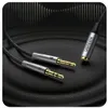 A close-up shot of a Ugreen audio splitter cable with 3.5mm connectors, lying on a textured dark surface. Podgląd zdjęcia produktu