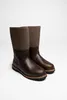 A pair of brown leather and felt boots on a white background. Produktbild-Vorschau
