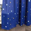 A close-up of a blue curtain with a star pattern, partially covering a white dresser. Produktbild-Vorschau