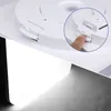 A close-up view of a white ceiling light fixture, showing a finger pressing a latch mechanism. The bottom part of the image shows the light emitting from the fixture. Anteprima dell’immagine prodotto