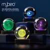 Four illuminated 3D crystal spheres depicting celestial bodies and galaxies, displayed on dark pedestals against a dark blue background. Voir les images du produit