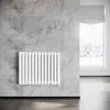 A white radiator mounted on a marble-tiled wall in a room with a window showing a winter scene. Anteprima dell’immagine prodotto