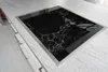 A close-up, angled view of a black marble-patterned glass stovetop insert set into a speckled gray countertop. Náhľad obrázku produktu