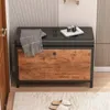 A shoe cabinet with a bench seat in a hallway, with a blanket and camera on top. Podgląd zdjęcia produktu