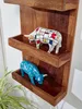 Two decorative bull figurines are displayed on a wooden wall shelf. Voir les images du produit