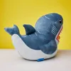 A plush toy shark sits on a white surface against a bright yellow background. Podgląd zdjęcia produktu