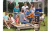 A group of friends enjoying a backyard party with music and food. Podgląd zdjęcia produktu