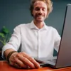 A man is using a laptop and plugging in a USB drive. Náhľad obrázku produktu