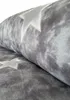 A close-up, rolled view of grey fleece fabric with a white star pattern. Produktbild-Vorschau