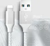 A close-up of two white USB charging cables with silver connectors, one with a lightning connector and the other with a USB-A connector. The background is a textured white fabric. Text and circular icons are present on the right side. Produktbild-Vorschau