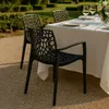 Outdoor dining set with chairs and a table covered with a white tablecloth, set in a garden. Produktbild-Vorschau