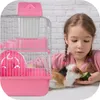 A young girl is interacting with a guinea pig next to its pink cage. Náhľad obrázku produktu