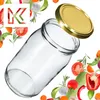 A clear glass jar with a gold lid is shown at an angle, surrounded by various fresh vegetables and herbs. Anteprima dell’immagine prodotto
