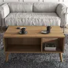A modern living room scene featuring a coffee table with cups and books, placed in front of a sofa. Náhled obrázku produktu