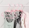 A close-up view of several pink baby clothes hangers with bows, holding various baby clothes. Produktbild-Vorschau