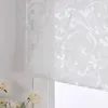 A close-up view of a white sheer curtain with a damask pattern, partially covering a window. Produktbild-Vorschau