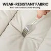 A hand is using a fork to scratch a beige fabric surface, demonstrating its wear-resistant quality. Produktbild-Vorschau
